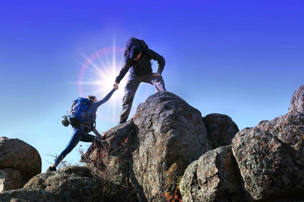 Personen helfen sich auf einen Berg zu steigen Soziales Engagement