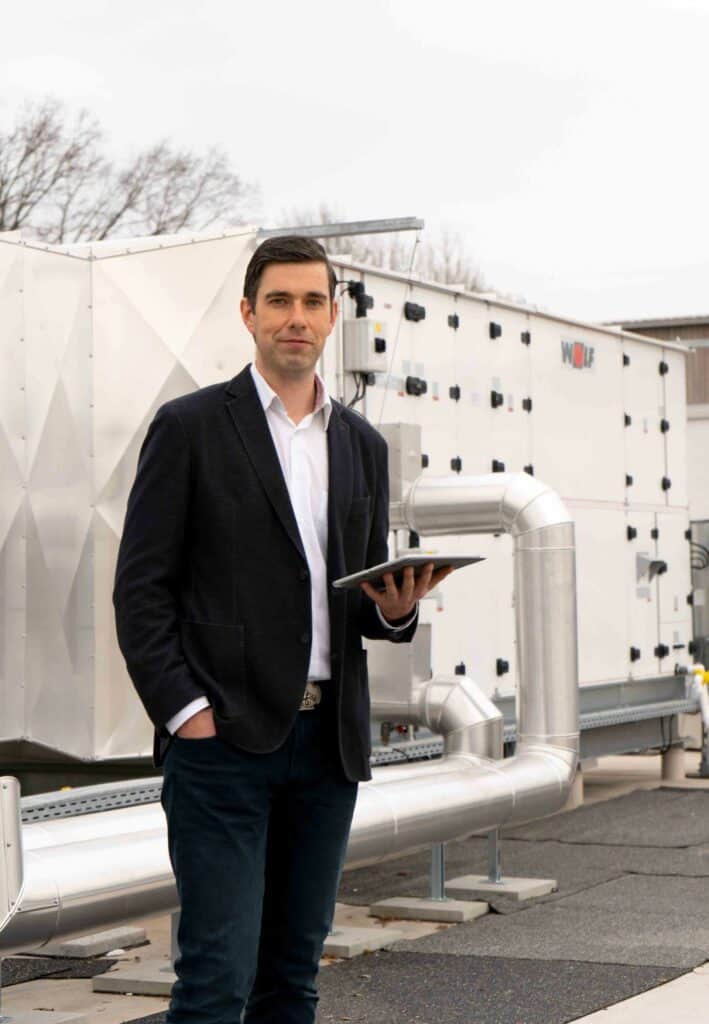 Projektleiter Melnikov auf dem Dach der Turnhalle - im Hintergrund ist die Belüftungsanlage zu sehen