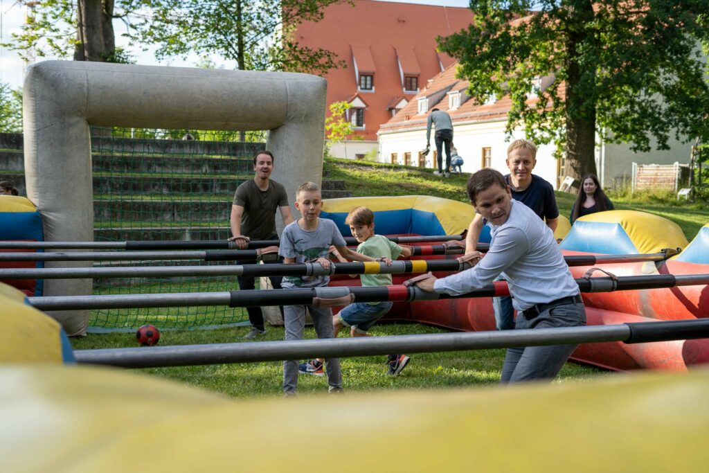 Personen spielen Menschen-Kicker beim COPLAN Sommerfest